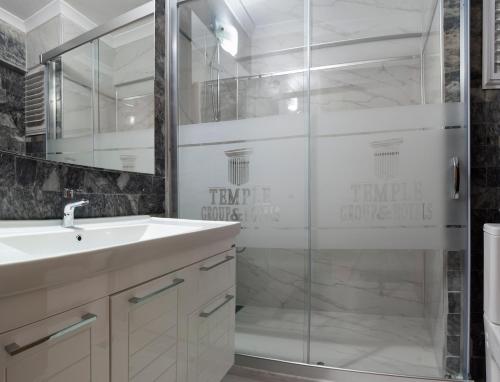 a bathroom with a sink and a glass shower at Temple Beach Hotel in Didim