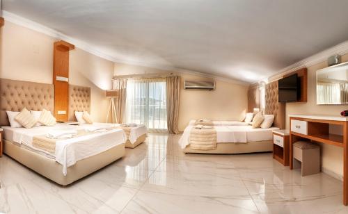 a hotel room with two beds and a sink at Temple Beach Hotel in Didim