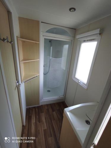 une salle de bain avec une douche et un lavabo et une fenêtre dans l'établissement Mobil home 5-6 personnes - climatisé, à Port-la-Nouvelle