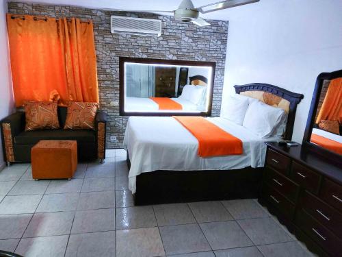 a bedroom with a large bed and a mirror at Residence Tropical Garden in Boca Chica