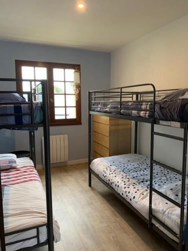 une chambre avec deux lits superposés et une fenêtre dans l'établissement La Villa du Payré, proche mer et piscine chauffée, à Jard-sur-Mer