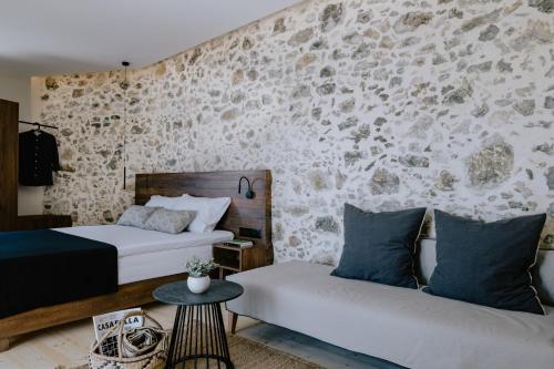 a bedroom with two beds and a stone wall at Antigone's Stone House in Plakias