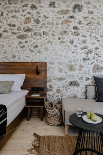 a bedroom with a bed and a table with a plate of fruit at Antigone's Stone House in Plakias