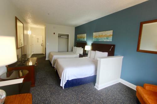 a hotel room with two beds and a blue wall at Hotel Pensacola in Pensacola