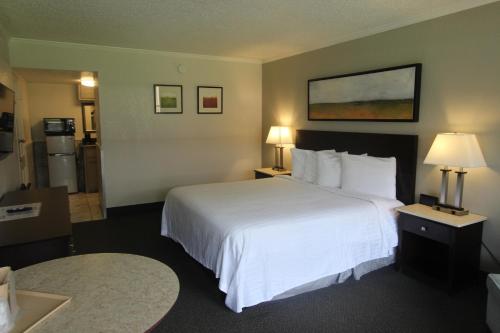 a hotel room with a large white bed and two lamps at At Home Inn - Pensacola in Pensacola