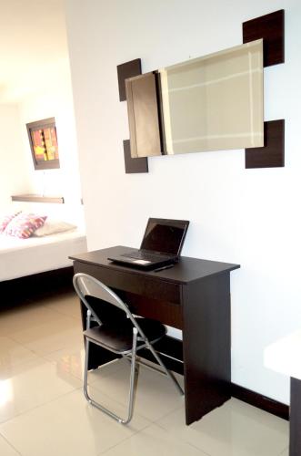 a desk with a laptop on it in a bedroom at Hotel Mare Apartasuite in Cali