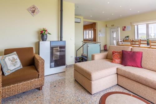 a living room with a couch and chairs and a tv at Casa do Alto do Vez in Balouta