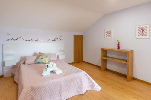 a bedroom with a bed with a teddy bear on it at Aldeamento Casas do Alto do Vez in Balouta