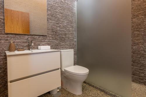 a bathroom with a white toilet and a sink at Aldeamento Casas do Alto do Vez in Balouta