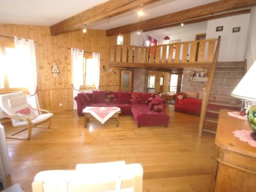 a living room with a red couch and a staircase at Authentic chalet with terrace in Harreberg in Hommert