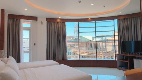 a bedroom with a bed and a large window at Quốc Thanh Hotel in Long Khanh