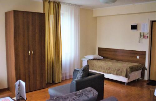 Habitación de hotel con cama y silla en Гостевой дом Бремен, en Maryino
