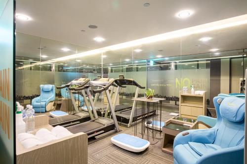 a salon with several treadmills and blue chairs at Hub Hotel Kaohsiung Yawan Branch in Kaohsiung
