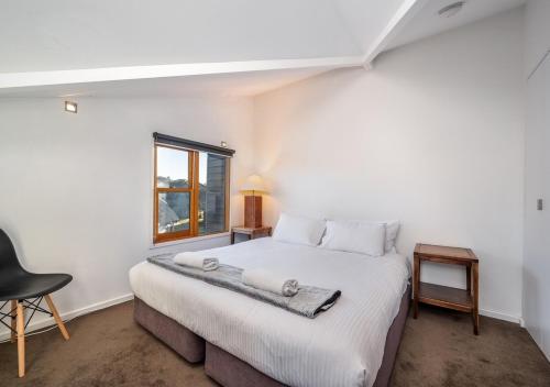 a bedroom with a large white bed with a window at Triggerplant 4 in Dinner Plain