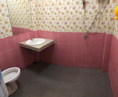 a pink bathroom with a sink and a toilet at Jingle Bells Resort in Ko Larn