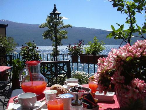 a table with food and a view of the water at Hotel Garnì Bartabel in Gargnano