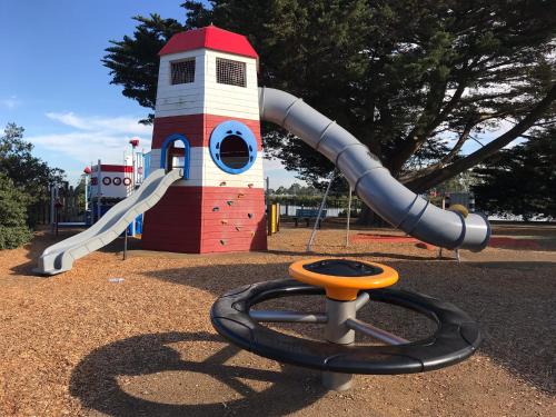 a playground with a slide in front of a lighthouse at That Seaside Cottage - Fully equipped home, 4 Bedrooms on the foreshore in Tooradin