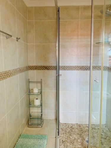 a shower with a glass door in a bathroom at Bokamoso Views in Rustenburg