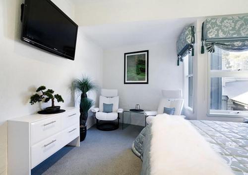 a bedroom with a bed and a flat screen tv at Snowgums 15 in Dinner Plain