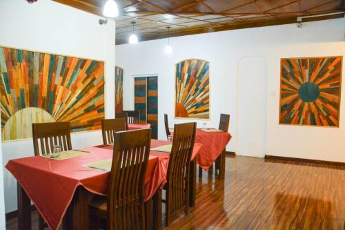 a room with tables and chairs and paintings on the walls at Little England Bungalow in Nuwara Eliya