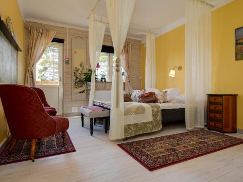 a bedroom with a canopy bed and a chair at Kolmårdsgården in Kolmården