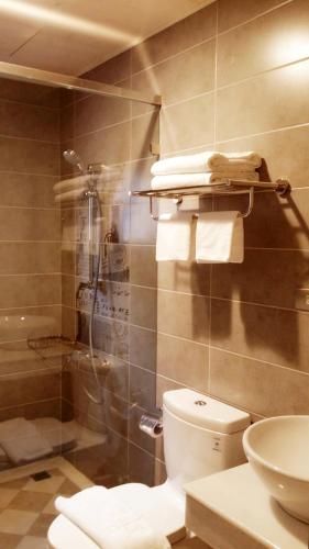 a bathroom with a shower and a toilet and towels at TK Happiness 168 B&B in Donggang