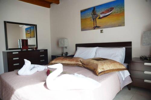 two swans sitting on a bed in a bedroom at Mary's dreams Villa in Symi