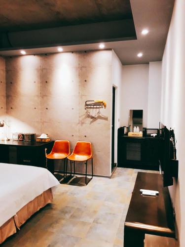 a hotel room with a bed and two orange chairs at TK Happiness 168 B&B in Donggang
