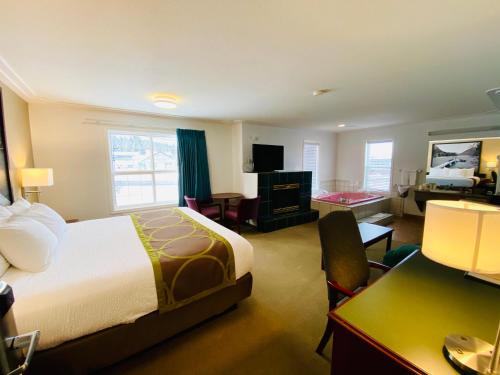 ein Hotelzimmer mit einem Bett und einem Schreibtisch in der Unterkunft Super 8 by Wyndham 100 Mile House in One Hundred Mile House