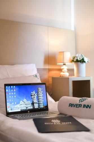 a laptop computer sitting on top of a bed at River Inn in Stari Banovci