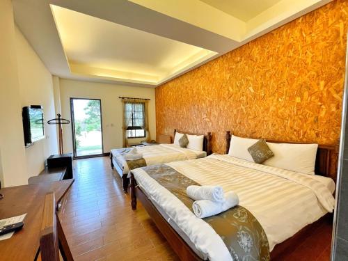 ein Hotelzimmer mit 2 Betten und einem Schreibtisch in der Unterkunft Fun Cows in Eluan