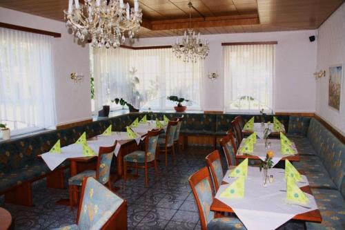 厄赫林根的住宿－席勒鋪拉茨酒店，用餐室配有桌椅和黄色餐巾