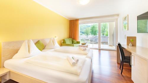 um quarto de hotel com duas camas e uma secretária em Wohlfühlpension Kristan em Sankt Kanzian