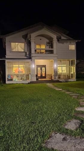 a large white house with a lawn in front of it at Star House in Tianfu