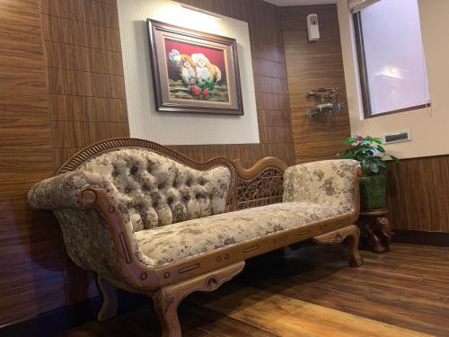 a couch in a room with a painting on the wall at Beverly villa in Ooty