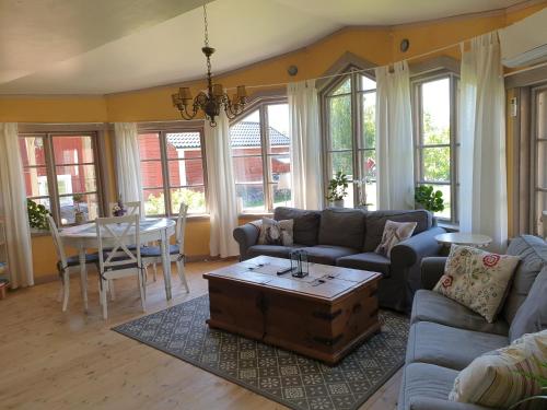 ein Wohnzimmer mit einem Sofa und einem Tisch in der Unterkunft Spiragården in Glanshammar