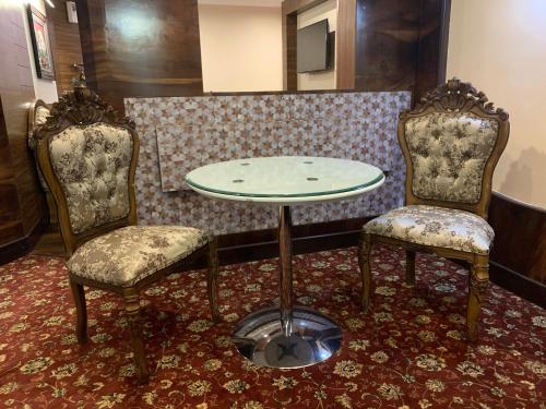 two chairs and a table and a table and two chairs at Beverly villa in Ooty