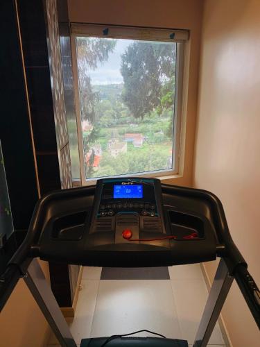 a room with a treadmill in front of a window at Beverly villa in Ooty