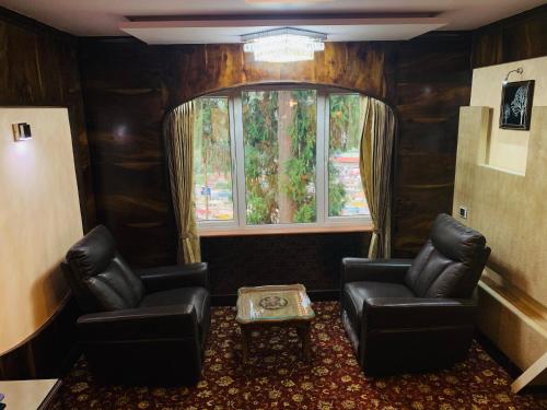 a waiting room with two chairs and a window at Beverly villa in Ooty