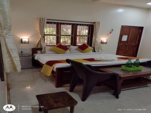 a bedroom with a large bed and a table at Redstone House by Oxystays Hospitality in Ganpatipule