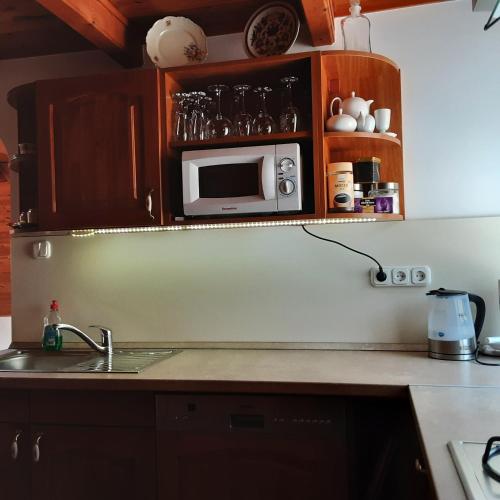 a kitchen with a sink and a microwave at Jázmin Apartman in Tihany