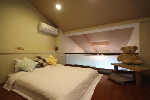 a teddy bear sitting on a table in a bedroom at Star House in Tianfu