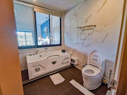 a bathroom with a toilet and a sink and a window at Phuengluang Riverside Hotel Chanthaburi in Chanthaburi