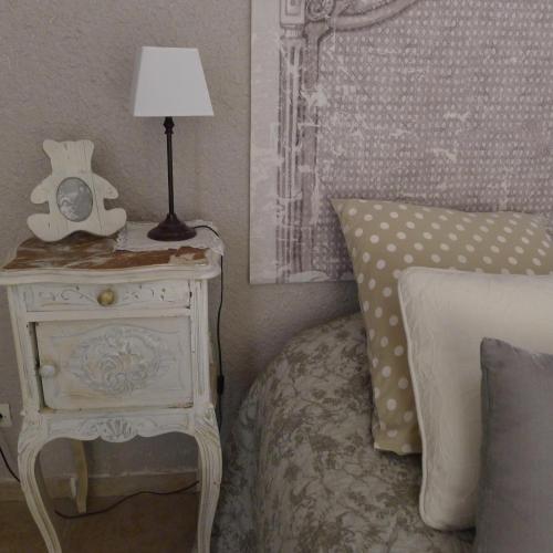 a bedroom with a bed and a table with a lamp at Domaine de la Manse in Villeneuve-de-Berg