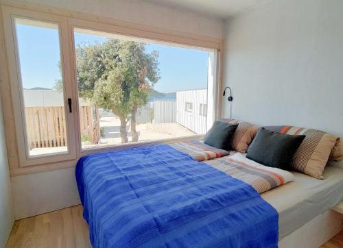 ein Bett in einem Zimmer mit einem großen Fenster in der Unterkunft Camp Buqez 45 - Villa Artica in Pakoštane