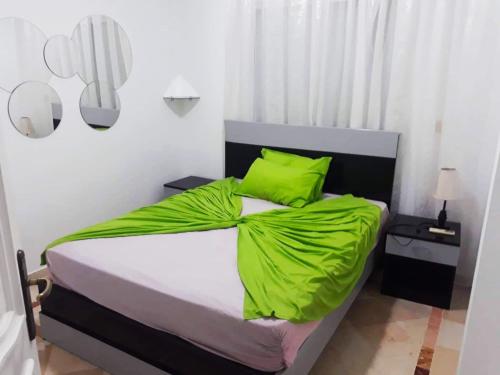a bedroom with a bed with lime green pillows at S+2 zone touristique Mahdia in Hiboun