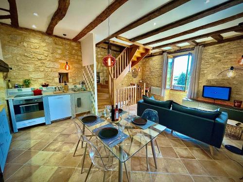 une cuisine et un salon avec une table et un canapé dans l'établissement Cottage du Capiol en Périgord, à Cénac-et-Saint-Julien