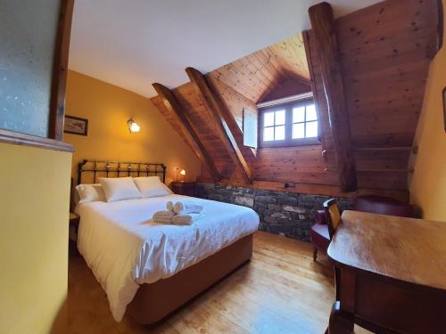 um quarto com uma cama, uma janela e uma mesa em Posada Magoria em Ansó