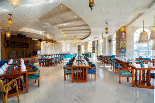 a dining room with wooden tables and blue chairs at Ramee Royal Resort & Spa - Udaipur in Udaipur