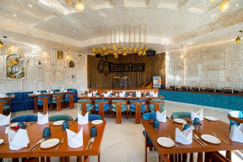 a dining room with wooden tables and blue chairs at Ramee Royal Resort & Spa - Udaipur in Udaipur
